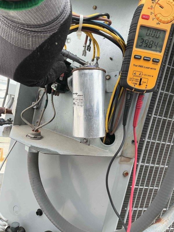 Completed comprehensive Clean and Check maintenance on rooftop AC system, humidifier, and water heater per Comfort Plan agreement. Performed diagnostic testing on rooftop unit including capacitor inspection and electrical measurements using digital multimeter, recording voltage and capacitance readings to verify proper system operation. Reviewed existing furnace repair estimate with customer for future scheduling consideration, with all systems currently operating within normal parameters following maintenance procedures.