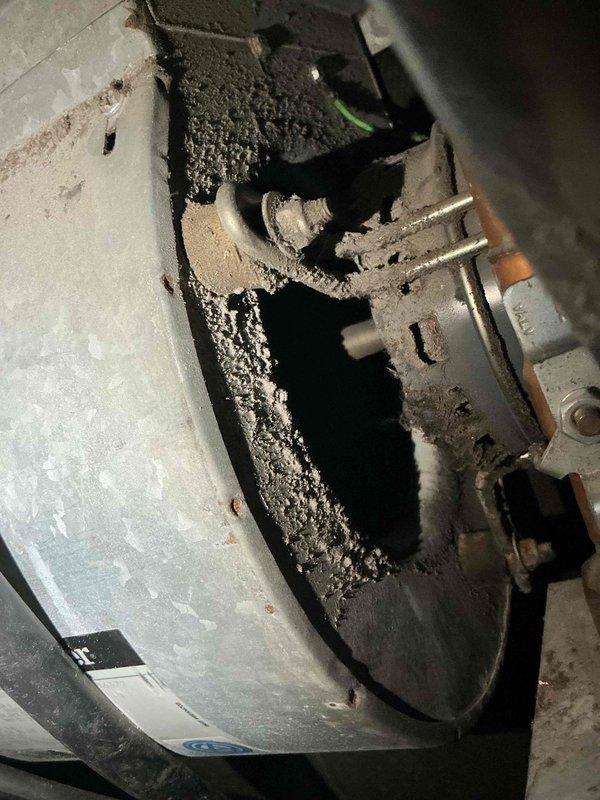 Responded to emergency service call for ice buildup on air conditioning system filter. Upon arrival, discovered catastrophic water heater failure with severe fire damage and structural compromise to tank top, creating safety hazard in proximity to HVAC equipment. Documented extensive deterioration and charring around failed water heater opening. Assessed residential HVAC system for ice formation on filter as reported, likely caused by restricted airflow or refrigerant issues. Collected all equipment information and photographed damaged water heater and surrounding areas for documentation purposes. Advised customer of water heater safety concerns requiring immediate attention and provided diagnostic assessment of air conditioning system performance.