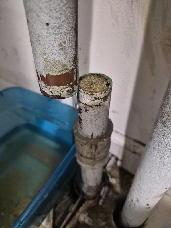 Responded to report of air conditioning system leaking. Upon arrival, conducted thorough inspection of HVAC system and associated plumbing connections. Investigation revealed significant corrosion and deterioration on metal piping in mechanical space, with heavy rust damage and peeling protective coating on larger diameter pipe. Identified green corrosion and oxidation on smaller adjacent pipe with accumulated moisture damage. Further inspection of plumbing assembly showed aged copper pipe with oxidation and tarnishing connected to white PVC pipes secured with metal clamps. Noted visible wear, grime accumulation, and signs of long-term moisture exposure on all piping components. Documented existing conditions with photographs showing extent of corrosion, paint deterioration, and surface degradation throughout pipe assembly. Determined source of reported leak and assessed whether issue was related to building infrastructure or tenant-specific equipment. Provided diagnostic findings and 