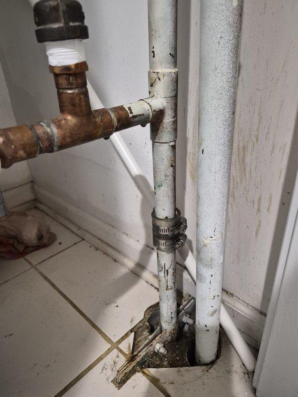 Responded to report of air conditioning system leaking. Upon arrival, conducted thorough inspection of HVAC system and associated plumbing connections. Investigation revealed significant corrosion and deterioration on metal piping in mechanical space, with heavy rust damage and peeling protective coating on larger diameter pipe. Identified green corrosion and oxidation on smaller adjacent pipe with accumulated moisture damage. Further inspection of plumbing assembly showed aged copper pipe with oxidation and tarnishing connected to white PVC pipes secured with metal clamps. Noted visible wear, grime accumulation, and signs of long-term moisture exposure on all piping components. Documented existing conditions with photographs showing extent of corrosion, paint deterioration, and surface degradation throughout pipe assembly. Determined source of reported leak and assessed whether issue was related to building infrastructure or tenant-specific equipment. Provided diagnostic findings and 