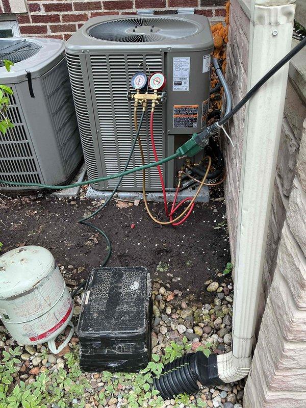 Corrected improper condenser installation that was positioned too close to building structure, preventing access to service ports and electrical compartment. Recovered refrigerant charge and disconnected unit. Added pea gravel base for proper leveling and rotated condenser 90 degrees to ensure adequate service clearance. Extended refrigerant lines using 3/4" and 3/8" line sets with press couplings and appropriate fittings. Replaced electrical whip to accommodate new unit orientation. Performed complete pressure test and vacuum procedure, recharged system to manufacturer specifications, and tested for proper operation with homeowner present.