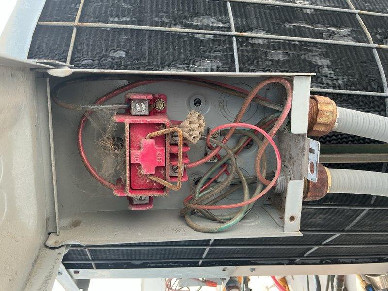 Completed routine tune-up and maintenance on rooftop HVAC system consisting of cylindrical air conditioning unit and condenser. Inspected electrical junction box beneath solar panel array, verified wire connections and terminals were secure, and documented aging equipment condition. Discussed potential system replacement options and hydronic coil zone valve installation with property owner based on equipment age and neighbor referral.