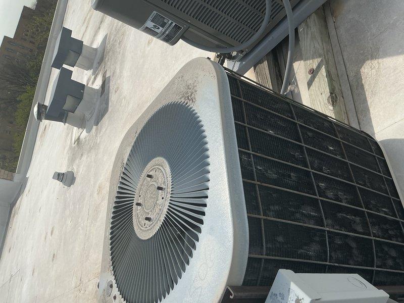 Completed routine tune-up and maintenance on rooftop HVAC system consisting of cylindrical air conditioning unit and condenser. Inspected electrical junction box beneath solar panel array, verified wire connections and terminals were secure, and documented aging equipment condition. Discussed potential system replacement options and hydronic coil zone valve installation with property owner based on equipment age and neighbor referral.