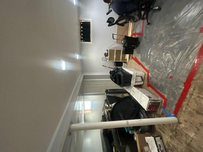 Conducted HVAC assessment for property currently without central air conditioning system. Customer relies on portable fans for cooling, though an existing coil is present on-site. Basement flooding occurred affecting the furnace location, requiring evaluation of equipment and potential water damage to heating system components. Documented existing HVAC infrastructure including control panel and corridor work area with protective measures in place. Provided estimate for central air conditioning installation options compatible with existing coil and assessed furnace condition following flood event.