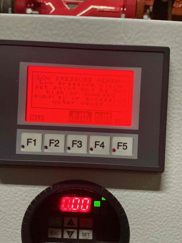 Continued diagnostic evaluation of commercial boiler booster pump system experiencing low pressure alarm condition. Inspected control panel interface, pressure monitoring display reading 0.00, and associated pump assembly with piping network including isolation valves and Y-strainer. Coordinated with office to establish approval process through property management for additional repairs required to resolve system malfunction.