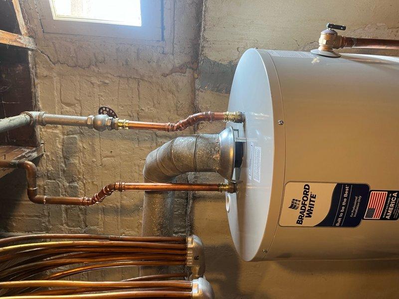 Replaced existing 50-gallon tanked water heater with new unit in basement utility area. Installation included connecting copper supply lines, PVC drain piping, pressure relief valve, and expansion tank to ensure proper system operation and code compliance. Verified outlet water temperature at 45°F during testing phase and confirmed all connections were secure and leak-free upon completion.
