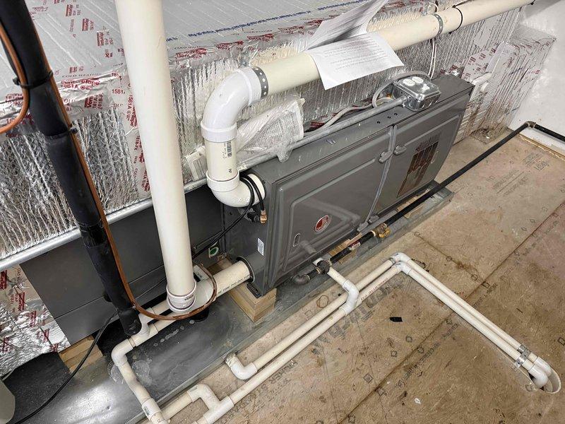 Completed spring maintenance clean and check on two-system HVAC installation per comfort plan protocol. Performed comprehensive inspection of air handler unit and evaporator coil assembly, documenting equipment specifications and model information. Inspected evaporator coil fins for cleanliness and airflow efficiency, noting minor dust accumulation typical of normal operation. Verified proper operation of condensate drain lines and PVC piping network, confirmed refrigerant line insulation integrity, and checked all ductwork connections including flexible insulated ducts and rigid metal components. Captured photographic documentation of equipment condition including coil assembly and complete system installation for service records. All systems operational and functioning within manufacturer specifications.