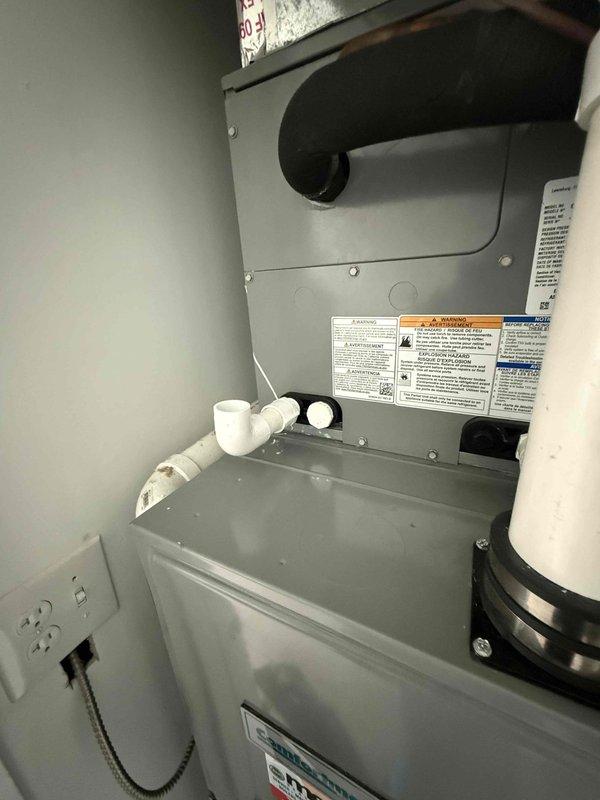 Responded to water leak issue on second floor HVAC unit where three drain connections were actively leaking and had triggered the water detection device. Upon inspection, identified compromised PVC drainage connections requiring replacement with properly sized 3/4-inch PVC piping to restore proper condensate drainage to the system. Documented equipment information and captured photographic evidence of the furnace installation and drainage configuration within the utility closet for service records.