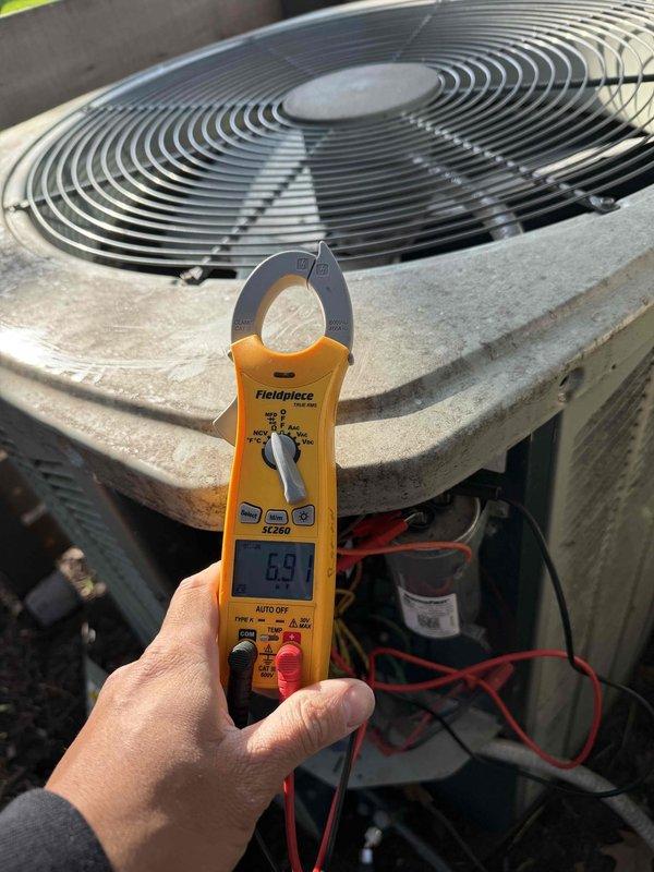 Completed air conditioning clean and check per service comfort plan. Performed system diagnostics with electrical measurements showing 5.9 amp draw and verified suction line temperature at 53°F. Unit operating within normal parameters with all components inspected and tested.
