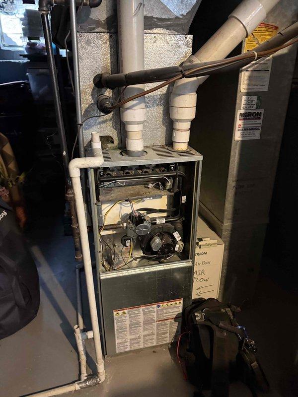 Responded to no heat or cooling complaint with thermostat not communicating with HVAC system. Upon arrival, inspected furnace and found internal components accessible with front panel removed. Verified thermostat wiring connections at furnace control board and traced communication failure between thermostat and equipment. Diagnosed lack of proper signal transmission preventing both heating and cooling operation, confirming customer's reported symptoms of complete system non-response.