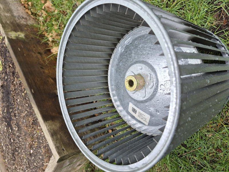 Performed blower wheel cleaning on residential furnace system. Removed blower assembly from unit, extracted heavily soiled squirrel cage fan wheel showing significant dirt and debris accumulation on blades, and thoroughly cleaned component before reinstallation and system testing.