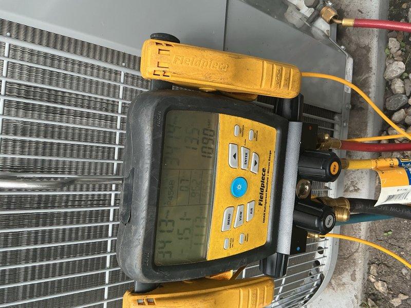 Returned to site to verify refrigerant charge levels on recently installed complete HVAC system and investigate reported second-floor leak. Connected digital manifold gauges to outdoor condensing unit service ports and performed comprehensive refrigerant analysis, confirming proper charge and system pressures. Conducted thorough inspection of refrigerant line connections, service valves, and copper line routing along exterior wall to identify source of second-floor moisture issue.