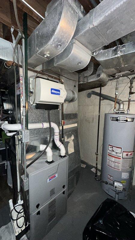 Conducted on-site assessment for installation of new flue pipe and chimney sleeve for existing HVAC system. Evaluated current furnace venting configuration with PVC intake and exhaust piping, inspected water heater flue requirements, and documented existing mechanical room conditions including ductwork routing and equipment placement to determine proper flue sizing and chimney penetration specifications for code-compliant installation.