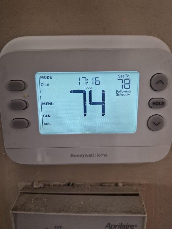 Responded to service call for refrigerant charge verification on residential cooling system. Upon arrival, verified thermostat operation showing 74°F setpoint with system actively calling for cooling. Performed system diagnostics and documented equipment conditions with photographic evidence for service records.