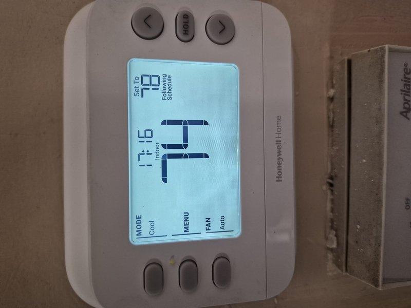 Responded to service call for refrigerant charge verification on residential cooling system. Upon arrival, verified thermostat operation showing 74°F setpoint with system actively calling for cooling. Performed system diagnostics and documented equipment conditions with photographic evidence for service records.