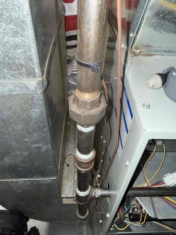 Responded to comfort plan member's concern regarding natural gas odor at furnace location. Performed comprehensive diagnostic inspection of gas-fired forced air heating system, including visual examination of heat exchanger, burner assembly, gas supply piping, and all associated components. Inspected gas valve, manifold connections, and union fittings for potential leak sources. Checked all accessible gas piping connections, including threaded brass fittings showing age-related patina and corrosion. Verified proper operation of blower motor assembly and electrical connections. Conducted thorough safety inspection of combustion chamber and venting system. All gas connections tested and found secure with no detectable leaks. System operational and safe for continued use.
