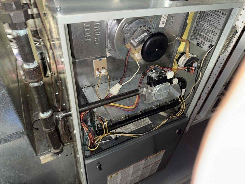 Responded to comfort plan member's concern regarding natural gas odor at furnace location. Performed comprehensive diagnostic inspection of gas-fired forced air heating system, including visual examination of heat exchanger, burner assembly, gas supply piping, and all associated components. Inspected gas valve, manifold connections, and union fittings for potential leak sources. Checked all accessible gas piping connections, including threaded brass fittings showing age-related patina and corrosion. Verified proper operation of blower motor assembly and electrical connections. Conducted thorough safety inspection of combustion chamber and venting system. All gas connections tested and found secure with no detectable leaks. System operational and safe for continued use.