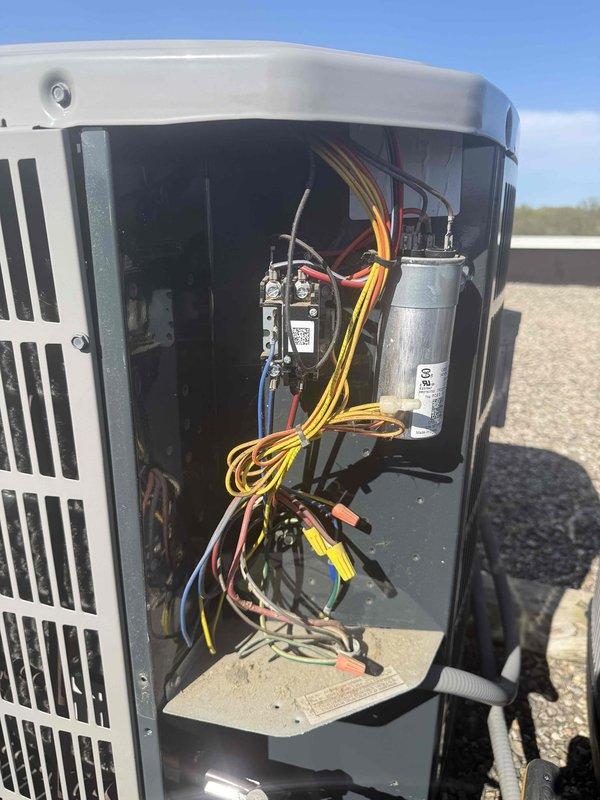 Responded to service call for frozen air conditioning unit. Upon arrival, system had been shut down by homeowner and coil had defrosted. Performed diagnostic inspection of outdoor condensing unit, accessing electrical compartment to examine capacitor, contactor, and wiring connections. Inspected evaporator coil for cleanliness and airflow restrictions. All electrical components tested within normal operating parameters. Documented equipment information and captured photos of unit's internal components and coil assembly for service records.