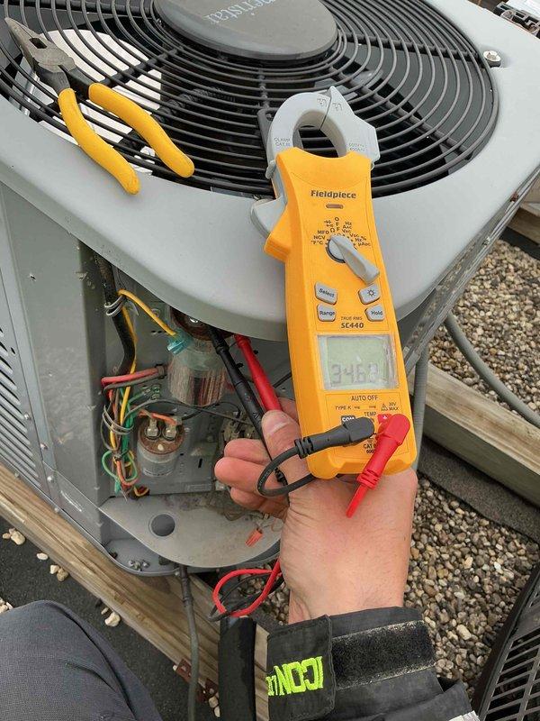 Performed clean and check service on single air conditioning system per building special protocol. Conducted electrical diagnostics using clamp meter, measuring voltage and amperage readings at the condenser unit to verify proper system operation. Installed 12x20x1 air filter and completed standard maintenance procedures with photographic documentation of electrical measurements and unit condition.