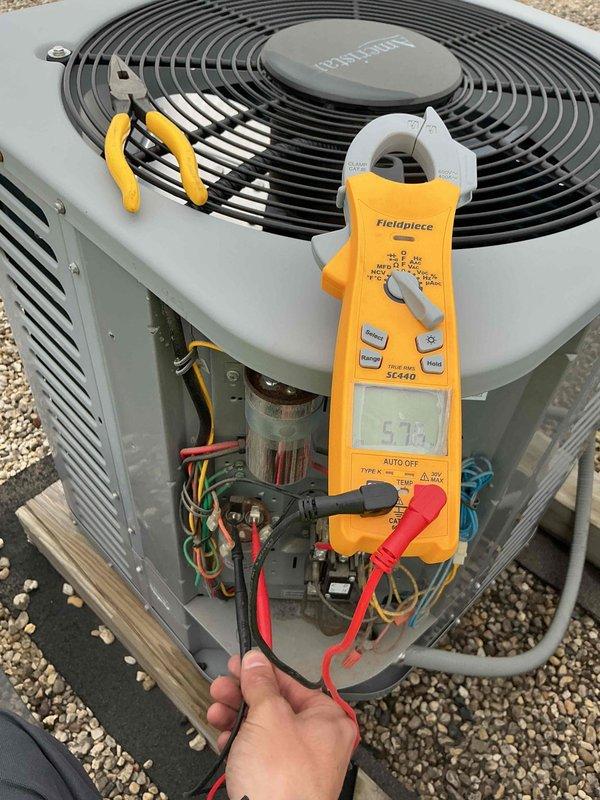 Performed clean and check service on single air conditioning system per building special protocol. Conducted electrical diagnostics using clamp meter, measuring voltage and amperage readings at the condenser unit to verify proper system operation. Installed 12x20x1 air filter and completed standard maintenance procedures with photographic documentation of electrical measurements and unit condition.