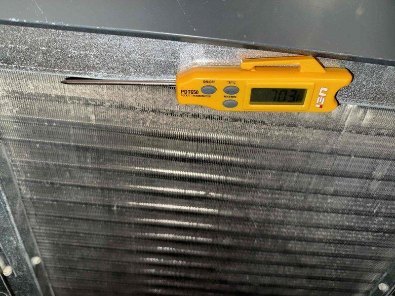 Completed routine maintenance tune-up on single HVAC system. Performed temperature diagnostics at evaporator coil, recording operational readings to verify proper system performance. Inspected coil condition, noting accumulated dust and debris between fins. Measured supply air temperature at 46.4°F, confirming adequate cooling capacity. System currently operating without filter installed; customer notified of missing filter requirement for optimal performance and equipment protection.