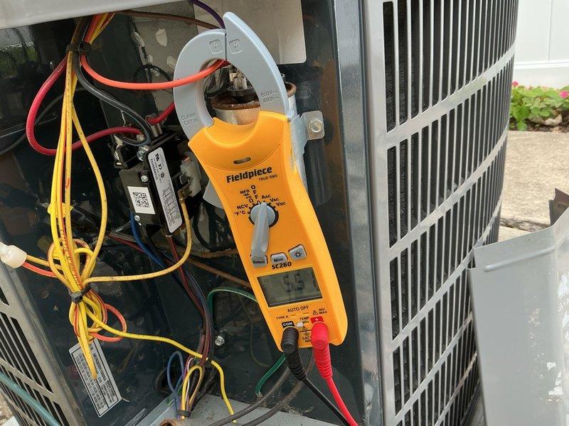 Completed spring clean and check on outdoor air conditioning unit per comfort plan agreement. Performed comprehensive electrical diagnostics using clamp meter, recording amperage draw of 4.5 amps and verified system voltages at 5.5V and 5.26V on capacitor circuits. Inspected internal electrical components including contactors, capacitors, and wiring connections; removed access panel to access electrical compartment for thorough examination. Cleaned condenser unit, checked fan assembly operation, and confirmed all components functioning within normal parameters. System operating properly with no deficiencies noted at time of service.