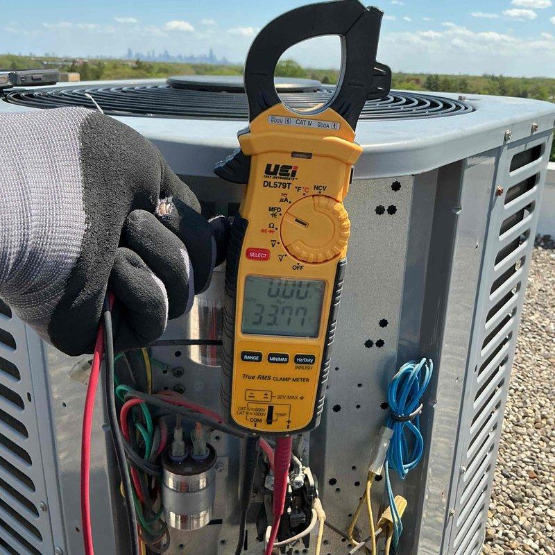 Performed comprehensive tune-up and diagnostics on rooftop-mounted air conditioning system. Utilized digital clamp meter to verify electrical readings and system performance, inspecting internal components including capacitors, wiring harnesses, and refrigerant line connections. Customer declined filter replacement as new filter was already installed; all equipment information documented in service tracking system and photographic documentation completed.