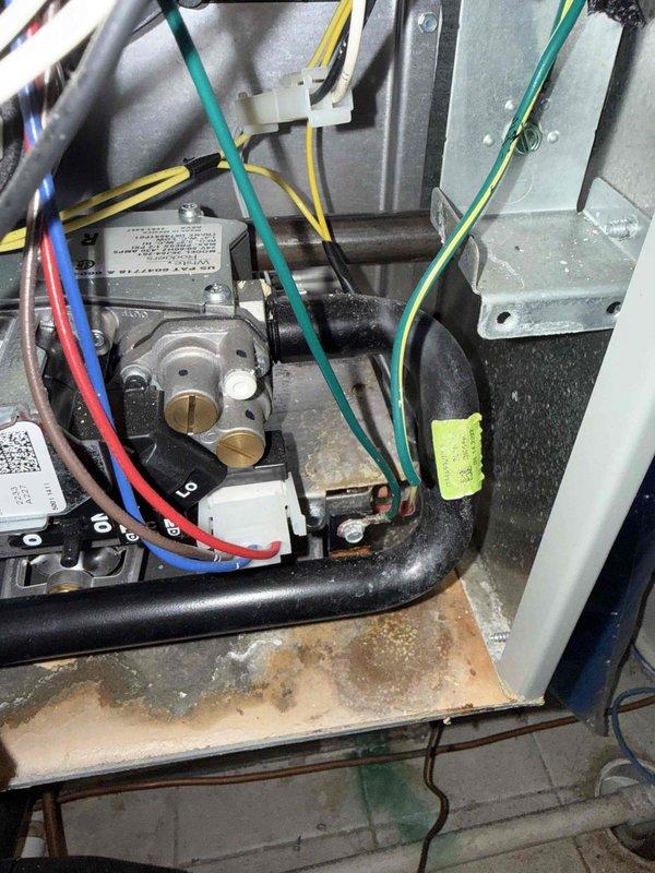 Responded to service call for reported water leak from furnace unit installed in 2022. Upon inspection, discovered significant water staining and discoloration on the condensate drain pan, indicating long-term moisture accumulation. Identified the source of the leak, cleared the condensate drainage system, and verified proper operation of the drain pan and associated components. Inspected gas valve assembly, blower housing, and all electrical connections for water damage. Confirmed all mechanical and electrical systems functioning properly with no further evidence of active leaking. System returned to normal operation with condensate properly draining.
