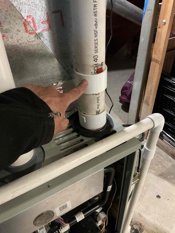 Responded to service call for reported furnace leak. Upon arrival, performed thorough inspection of HVAC system and associated components in mechanical space. Examined furnace unit, condensate drainage system, and connected ductwork for signs of water leakage. Inspected PVC condensate drain piping, connections, and mounting points for proper installation and potential failure points. Evaluated condensate pump assembly and drainage hose connections, noting condition of rubber hoses and clamp security on ductwork components. Assessed overall system operation and identified source of moisture concern. Documented equipment conditions with photographic evidence showing pipe connections, ductwork assembly, and mechanical room layout for service records.