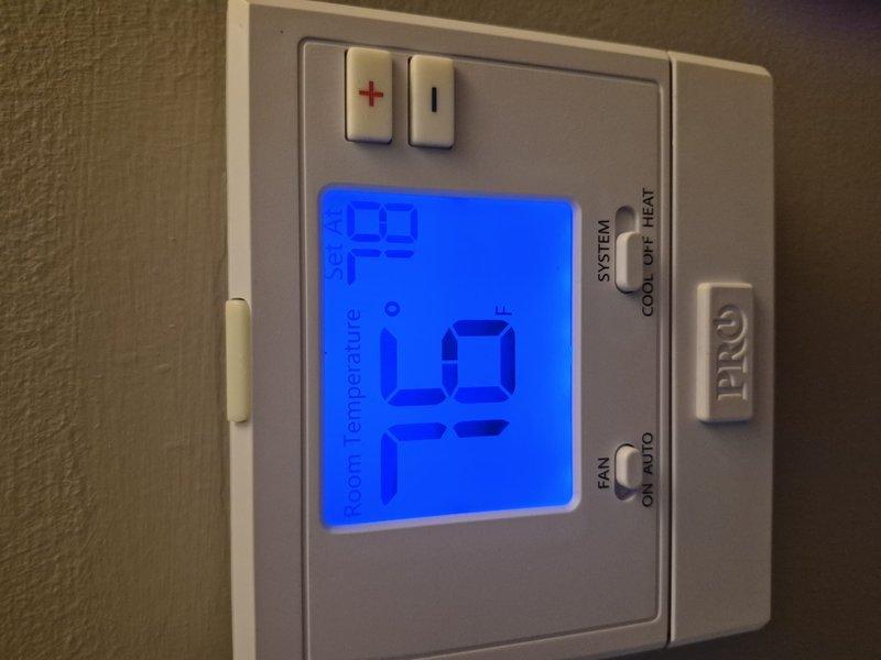 Completed spring tune-up maintenance on 2.5-ton residential air conditioning system for new customer. Performed comprehensive inspection of outdoor condenser unit, noting moderate debris accumulation on coil fins and surrounding cabinet area. Indoor air handler inspected and found in operational condition; customer declined filter replacement at this time. Verified thermostat operation showing room temperature at 79°F with proper display function and control settings. System operational and ready for cooling season.