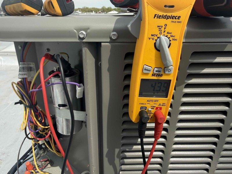 Completed preventive maintenance tune-up on rooftop HVAC system including air conditioning unit and air handler. Performed comprehensive system diagnostics using Fieldpiece SC260 multimeter, measuring capacitor performance at 435 microfarads to verify proper electrical operation. Replaced standard air filter with 16x20x1 filter, inspected electrical connections and wiring harness, and verified all components within manufacturer specifications for optimal system performance.