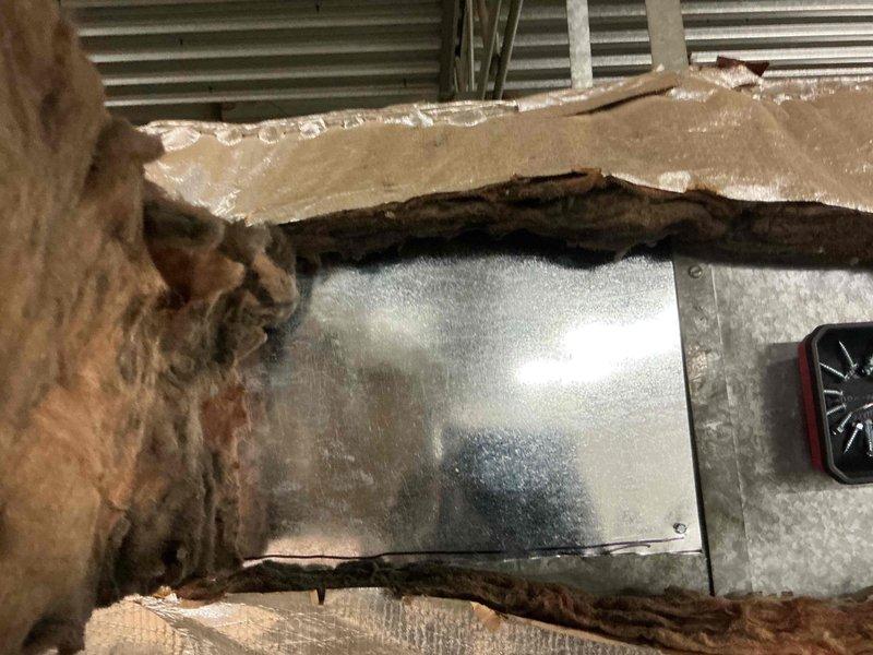 Responded to commercial HVAC ductwork repair request in ceiling plenum space. Upon inspection, found extensive deterioration of reflective insulation wrap on horizontal duct run, with multiple tears, holes, and compromised sections exposing underlying ductwork. Utilized sheet metal to patch damaged areas and secure structural integrity of duct system. Removed deteriorated insulation sections and re-wrapped ductwork with new reflective insulation material, ensuring proper coverage and sealing to maintain thermal efficiency and prevent energy loss. Completed repairs to restore duct insulation system to proper operating condition.
