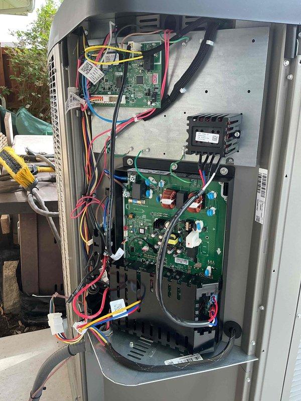 Completed installation of Lennox air conditioning condenser unit on new concrete pad adjacent to residential structure. System mounted on level concrete base with proper clearances maintained from building exterior and landscaping. All electrical connections completed including control boards, transformers, and wiring harnesses with appropriate color-coded conductors. Circuit boards properly secured within equipment cabinet, heat sink and control modules installed, and all manufacturer labels applied. Unit tested and operational upon completion.
