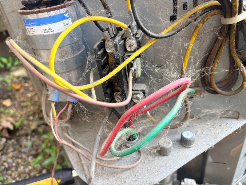 Completed annual air conditioning clean and check per comfort plan agreement on single system. Performed comprehensive maintenance including inspection of outdoor condenser unit, verified electrical connections and components, cleaned coils and removed debris accumulation including cobwebs from electrical terminals and wiring. All wiring connections found secure despite weathering; unit operating within normal parameters upon completion of service.