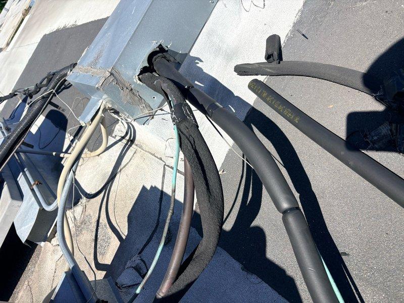 Replaced deteriorated lineset insulation on rooftop HVAC installation. Removed old damaged insulation from refrigerant lines and installed new black foam insulation sleeves, properly securing all sections with appropriate fasteners and cable ties to ensure proper thermal protection and energy efficiency of the system.