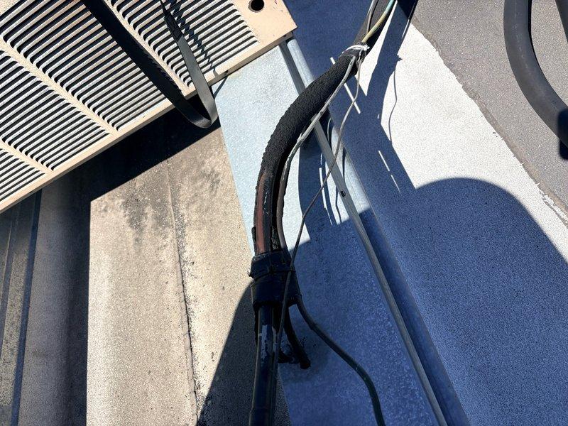 Replaced deteriorated lineset insulation on rooftop HVAC installation. Removed old damaged insulation from refrigerant lines and installed new black foam insulation sleeves, properly securing all sections with appropriate fasteners and cable ties to ensure proper thermal protection and energy efficiency of the system.