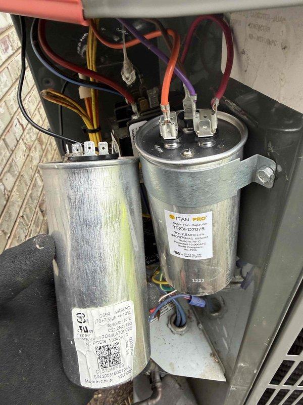 Replaced defective dual run capacitor (70/7.5 MFD) under warranty on residential air conditioning condenser unit. Removed failed OEM capacitor and installed TITAN PRO model TRCFD7075 replacement, reconnected all electrical terminals, and verified proper system operation. Unit returned to normal functionality with all components operating within specifications.
