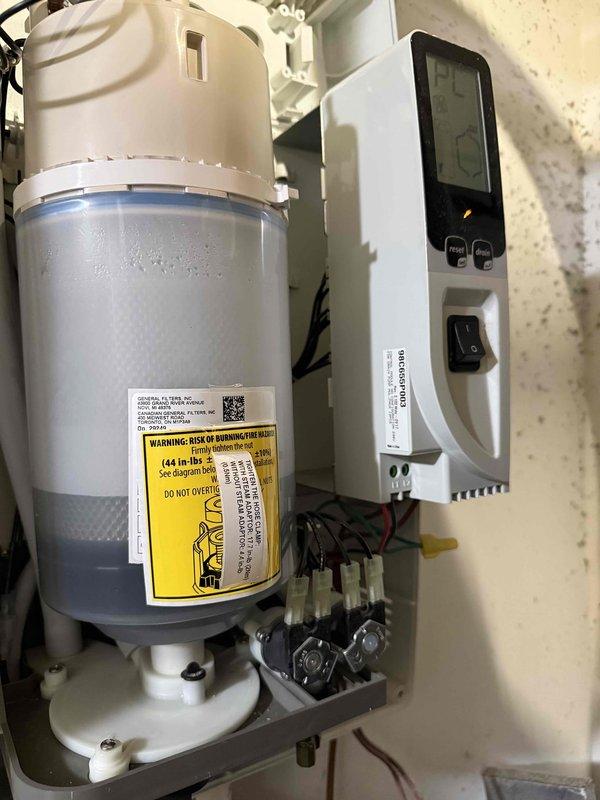 Performed prepaid maintenance visit and filter inspection on HVAC system. Inspected whole-home humidifier assembly and identified failed water treatment canister requiring replacement. Documented existing humidifier configuration including digital control panel, water supply connections, and electrical components. Replacement canister has been ordered and is awaiting delivery for follow-up installation to complete cleaning and maintenance service.