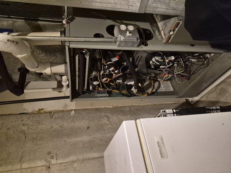 Responded to no cooling complaint on residential air conditioning system. Upon arrival, verified unit was not powering on at thermostat. Performed diagnostic evaluation of HVAC system including inspection of electrical components, control board, and wiring connections. Removed access panels to examine internal circuitry, capacitors, and terminal connections. Identified failed control board preventing system operation. Documented equipment condition with photos showing circuit board assembly, wire harnesses, and electrical connections. Discussed repair options and recommended replacement of defective control board to restore cooling functionality.