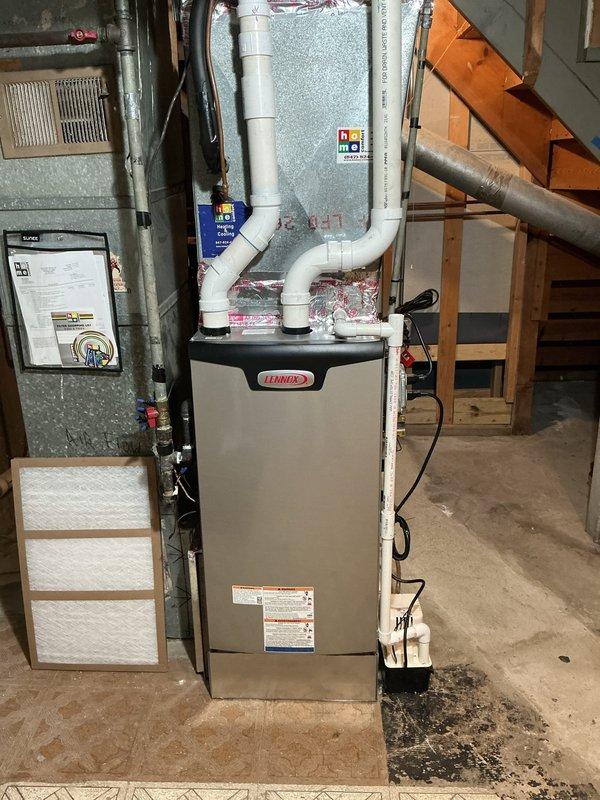 Removed and properly disposed of existing forced air furnace from basement installation. Installed new Lennox SLP99UH070XV36BK 66,000 BTU 3-stage variable speed forced air furnace (Cat #26J92) with furnace raised off ground using vibration pads to reduce operational noise and vibration transfer. 

Fabricated and installed necessary sheet metal transitions to connect new unit to existing supply and return air ductwork, with adjustments made to return air drop for proper airflow. Connected unit to existing gas line with appropriate fittings and valves, verified gas pressure and connections for safety compliance. Attached to existing electrical circuit with proper junction box installation and wiring connections.

Installed new condensate pump to handle drainage from high-efficiency furnace operation. Connected and properly pitched all PVC vent piping with support brackets installed every 4 feet as required by manufacturer specifications and code requirements. Secured exhaust venting to e