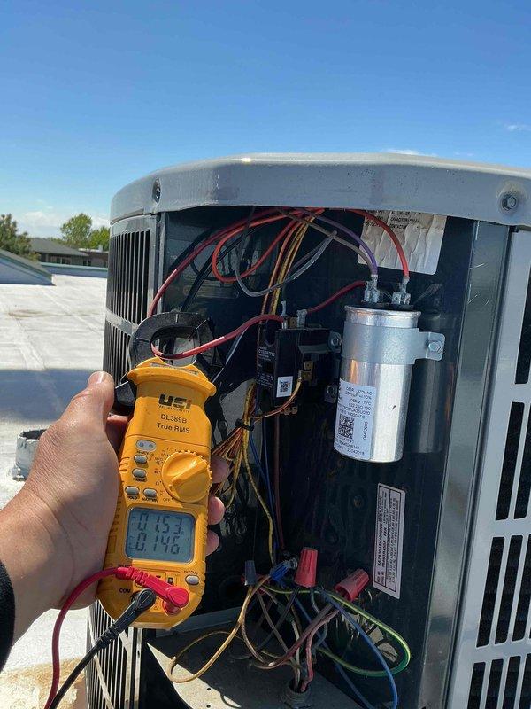 Performed complete tune-up and diagnostic inspection on rooftop air conditioning system. Conducted electrical testing using digital multimeter to verify capacitor functionality and contactor operation, confirming all readings within manufacturer specifications. Replaced air filter and verified thermostat operation showing proper communication with cooling equipment at 40°F setpoint in auto fan mode.