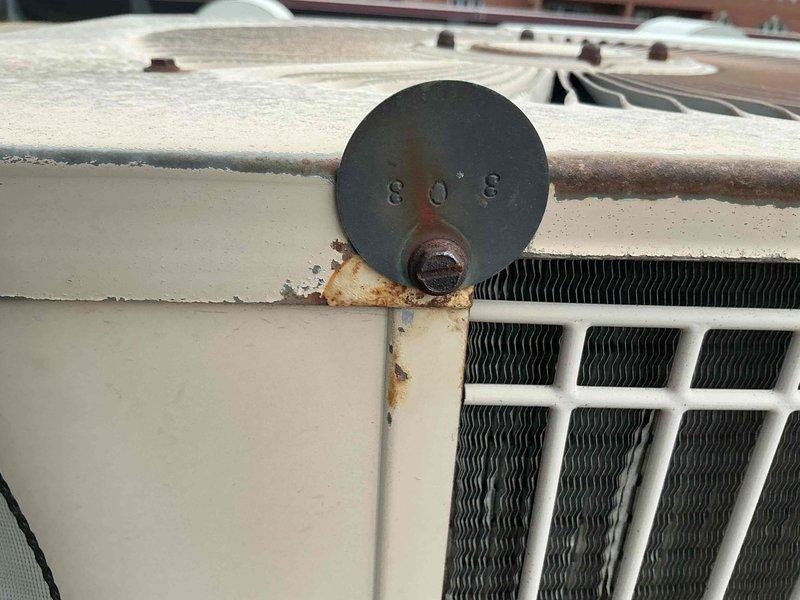Responded to no cooling complaint on rooftop-mounted air conditioning unit of undetermined age, estimated at 10+ years old. Upon arrival, found system completely inoperative with thermostat also shut down. Conducted visual inspection revealing aged condenser unit with significant rust deterioration on mounting platform, housing panels, and associated components. Extensive corrosion noted around equipment base and mounting hardware, indicating prolonged exposure to weather elements. Unit exhibited signs of advanced age including surface weathering, dust accumulation, and oxidation throughout. Performed diagnostic evaluation to determine extent of system failure and assessed overall equipment condition. Due to age of equipment, advanced deterioration, and complete system shutdown, recommended full system replacement as most cost-effective solution versus attempting repairs on aging unit with compromised structural integrity.
