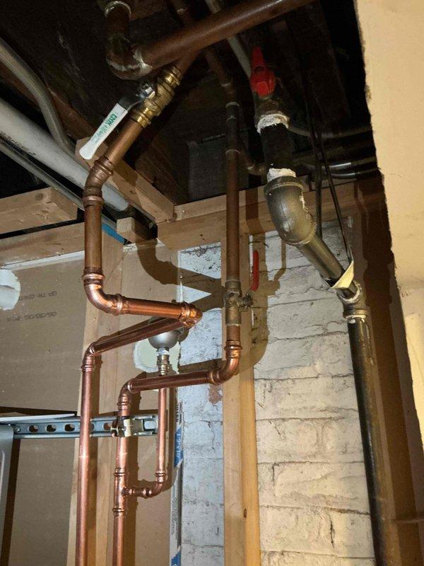 Removed and disposed of existing conventional water heater, then installed one Rinnai Sensi RXP199IN 199,000 BTU tankless water heater. Ran new PVC exhaust venting system through exterior wall and reconfigured gas piping to accommodate the new unit. Connected tankless heater to existing household water lines with new isolation and purging valves installed for future maintenance access. Installed recirculation valve under the furthest fixture to provide instant hot water delivery. Completed startup procedures, tested all connections for leaks, adjusted system settings for optimal performance, and performed comprehensive safety inspection to ensure proper operation of all components.