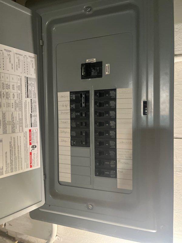 Completed preventative maintenance clean and check service on residential forced air furnace and air conditioning system per maintenance agreement guidelines. Inspected Trane TUE1C100A9481AD furnace unit manufactured August 2014, verified all technical specifications and safety certifications on equipment nameplate, and documented electrical panel configuration with circuit breaker arrangement and main disconnect switch for system reference.