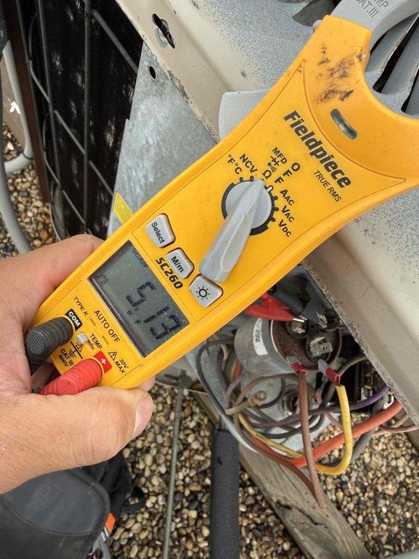 Responded to no cooling complaint on rooftop air conditioning unit serving condo apartment. Upon arrival, performed electrical diagnostics using digital multimeter to test voltage and amperage at outdoor condenser unit. Measurements taken at junction box revealed voltage reading of 30.55V and current draw of 15A during testing. Inspected electrical connections, wiring harness, and capacitor/contactor assembly with access panel removed to diagnose cooling failure.