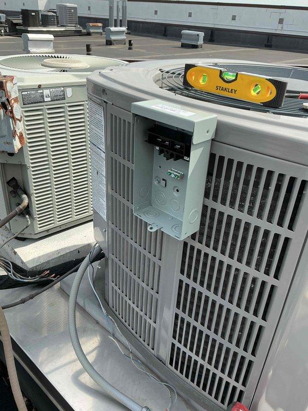 Responded to commercial rooftop HVAC system requiring electrical component replacement. Removed and replaced severely corroded electrical disconnect box that exhibited extensive rust damage and oxidation, which posed both safety and operational risks to the condensing unit. Installed new surge protector to provide electrical protection against voltage spikes and power fluctuations. All electrical connections were properly terminated and secured according to manufacturer specifications and NEC requirements. System tested and verified operational upon completion.