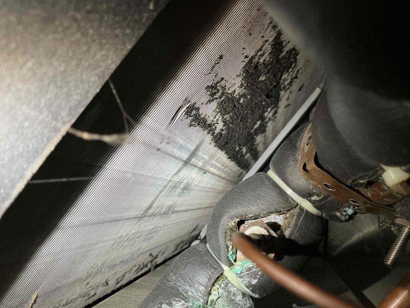 Responded to no cooling and unusual noise complaint on residential air conditioning system originally installed in 2016. Upon inspection, found evaporator coil heavily contaminated with debris and dust accumulation, restricting airflow and causing reduced cooling capacity. Observed copper refrigerant lines showing oxidation and corrosion. System had not received regular maintenance since 2020, contributing to deteriorated condition. Documented equipment condition with photos showing significant buildup on coil fins and corroded copper components requiring attention.