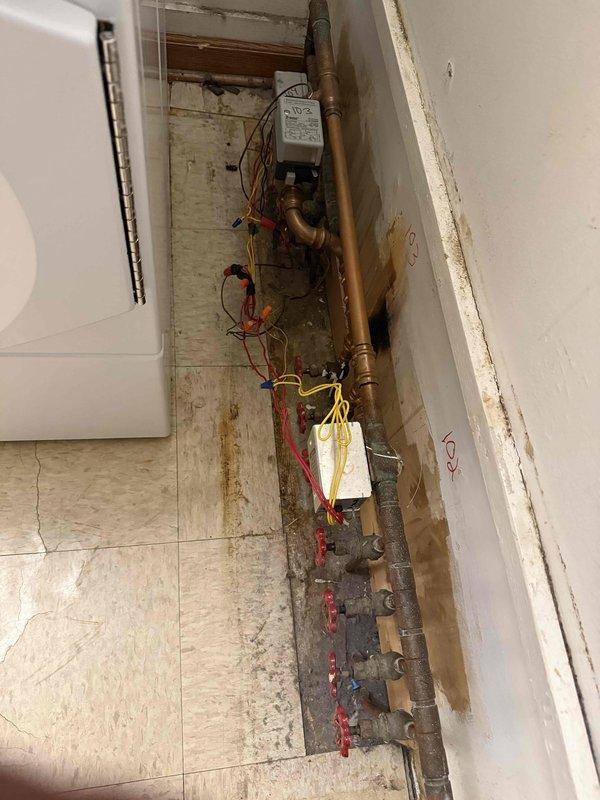 Responded to no cooling complaint on first floor. Upon arrival, inspected mechanical room and utility chase area. Found heating system valves in open position with boiler still operational during cooling season. Identified control wiring and zone valve configuration serving affected area. Documented existing plumbing infrastructure including copper piping, shut-off valves, and HVAC controls. Contacted office to report findings and coordinate approval process with property management for necessary repairs. Photographed mechanical equipment, valve positions, and control panel for documentation purposes.