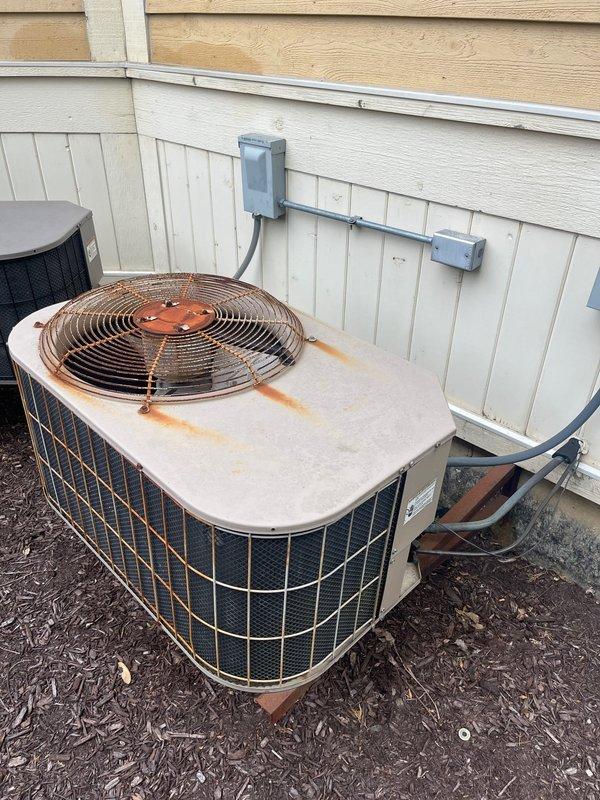 Completed comprehensive replacement estimate for residential HVAC system consisting of two air conditioning units and two furnaces, all exceeding 20 years of service life. Inspected existing attic-mounted furnace installation with current ductwork configuration and outdoor condensing unit showing significant rust corrosion and weathering on top panel and fan assembly, indicating end-of-life condition. Documented equipment specifications, spatial constraints, and existing infrastructure to provide accurate replacement recommendations for dual-zone comfort system upgrade.