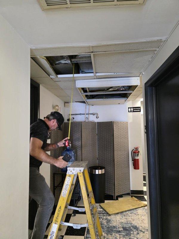 Completed a 3-ton air conditioning unit and evaporator coil replacement in a commercial front lobby area. Removed ceiling tiles and supports to access the existing Payne furnace coil located in the ceiling plenum above the entry hallway. Hoisted two AC units onto the roof and removed the existing 3-ton unit serving the lobby space, then installed the new equipment and restored ceiling components.